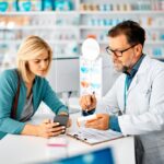 pharmacist showing patient how to use software