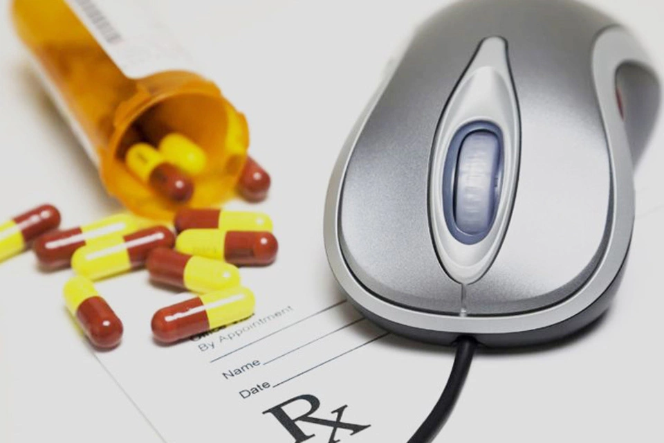 Computer mouse next to prescription pills