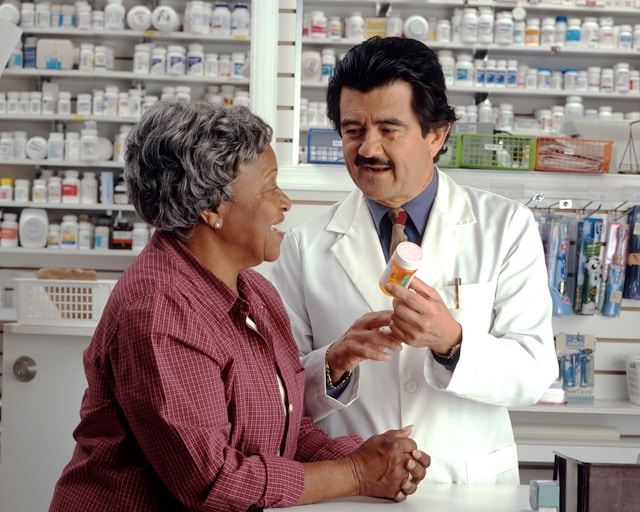 Pharmacist helping a woman inside the pharmacy