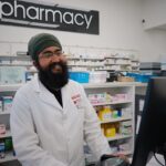 Smiling pharmacist using a computer