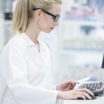 A pharmacist at a computer using a pharmacy software system