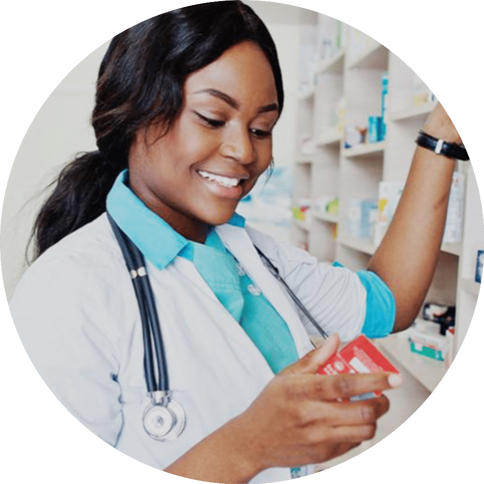 A pharmacist smiling as she stares at the medicine box she is holding
