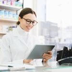 A female pharmacist reviewing information on a tablet