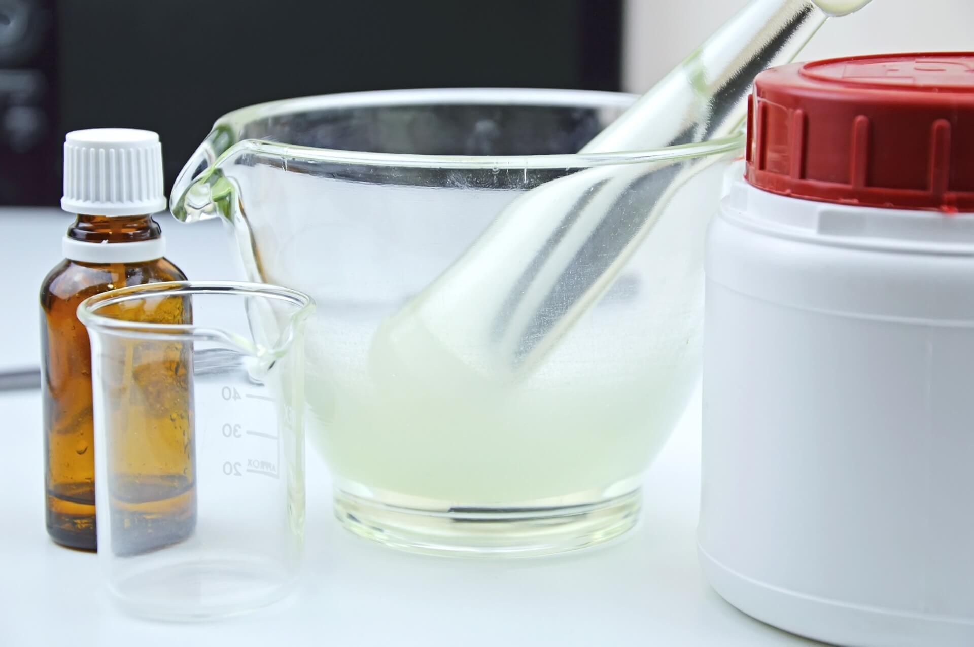 A photo of beakers and chemical bottles on a white table