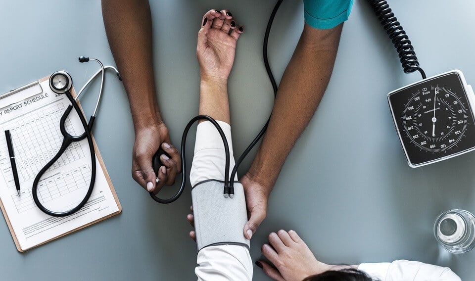 A doctor measuring the blood pressure of a patient.