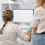 A pharmacist and pharmacy owner looking at a computer
