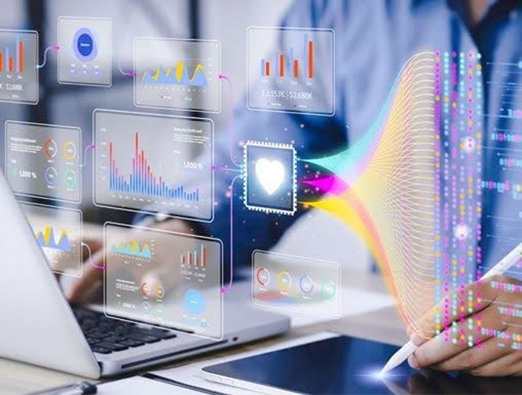 A pharmacist reviews graphs and charts using a computer and tablet