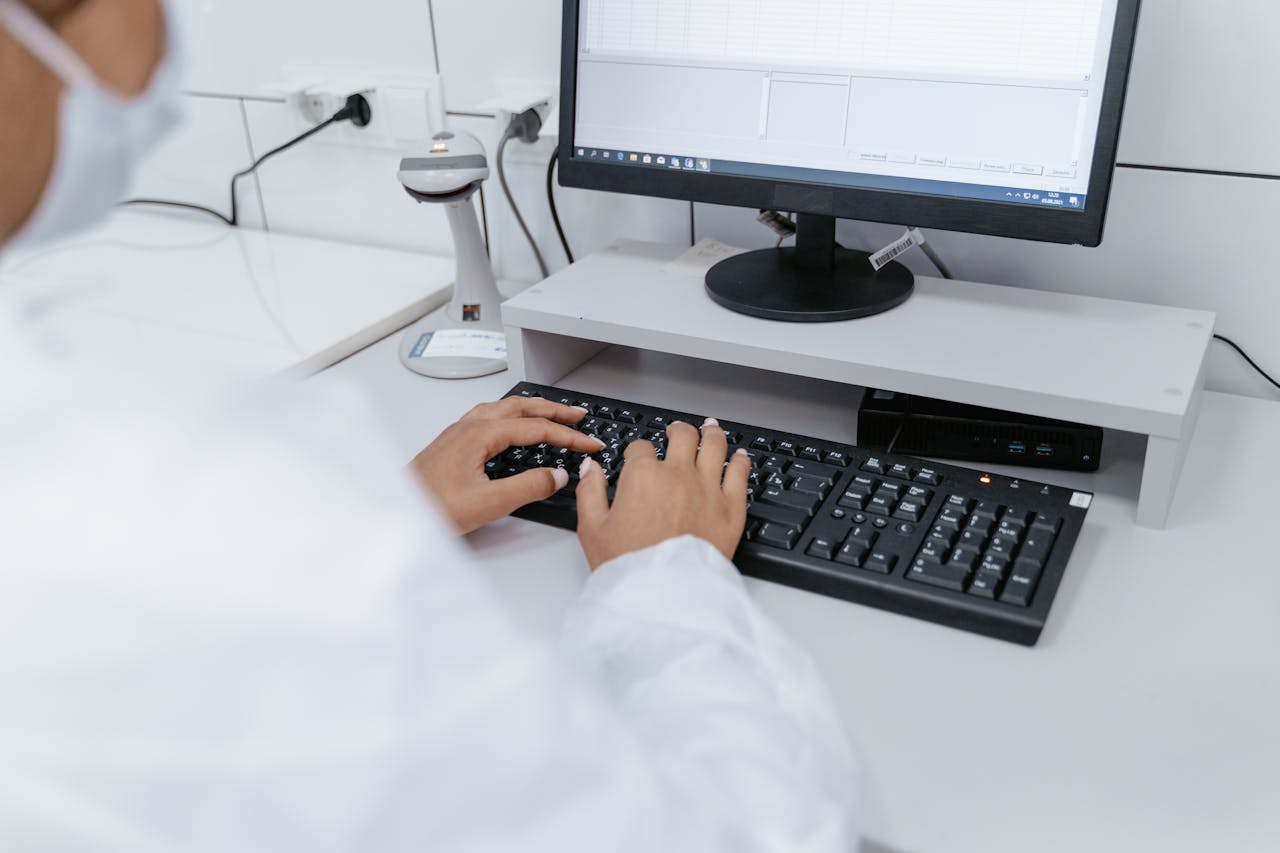 pharmacist-typing-pharmacy-computer Pharmacist typing at a pharmacy computer