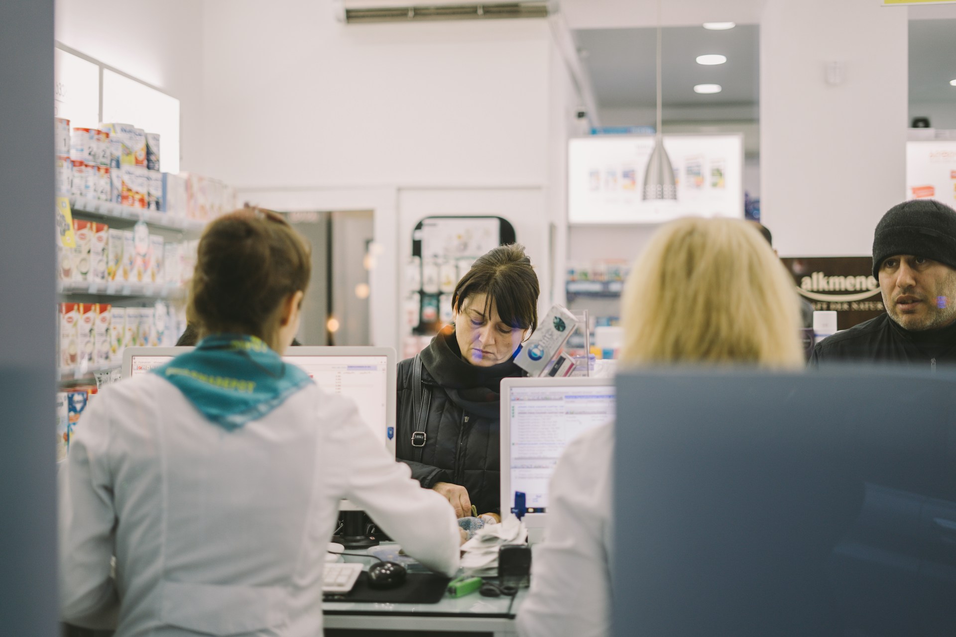 pharmacists-customers-pharmacy-counter Pharmacists assisting customers at a pharmacy counter
