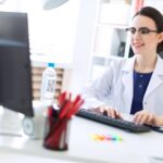 Independent pharmacist using modern pharmacy management software to manage prescriptions, patient communication, automation, and compliance